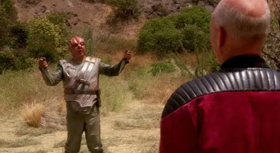 Dathon facing Jean-Luc Picard from behind on El-Adrel IV.