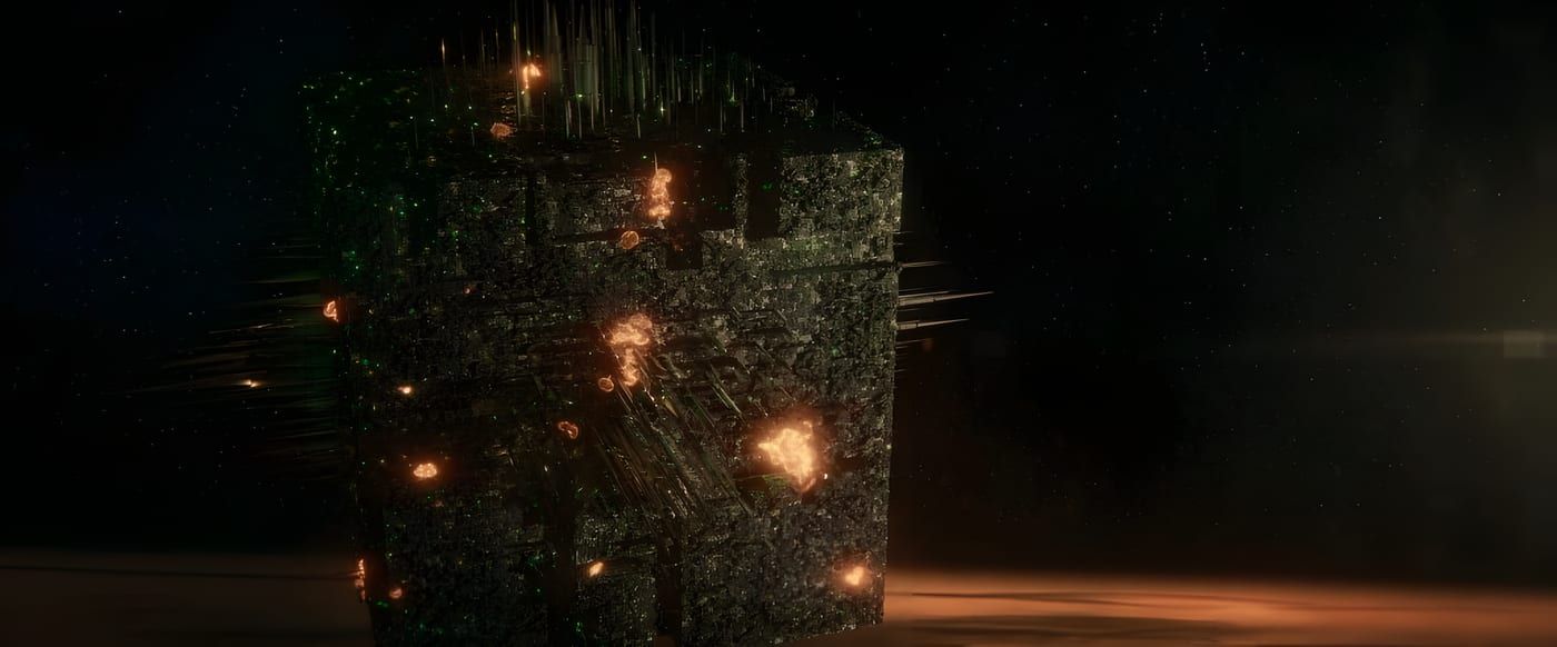 A massive Borg cube in silhouette against Jupiter's banded orange atmosphere, bright sun on the limb, green lights on the hull.