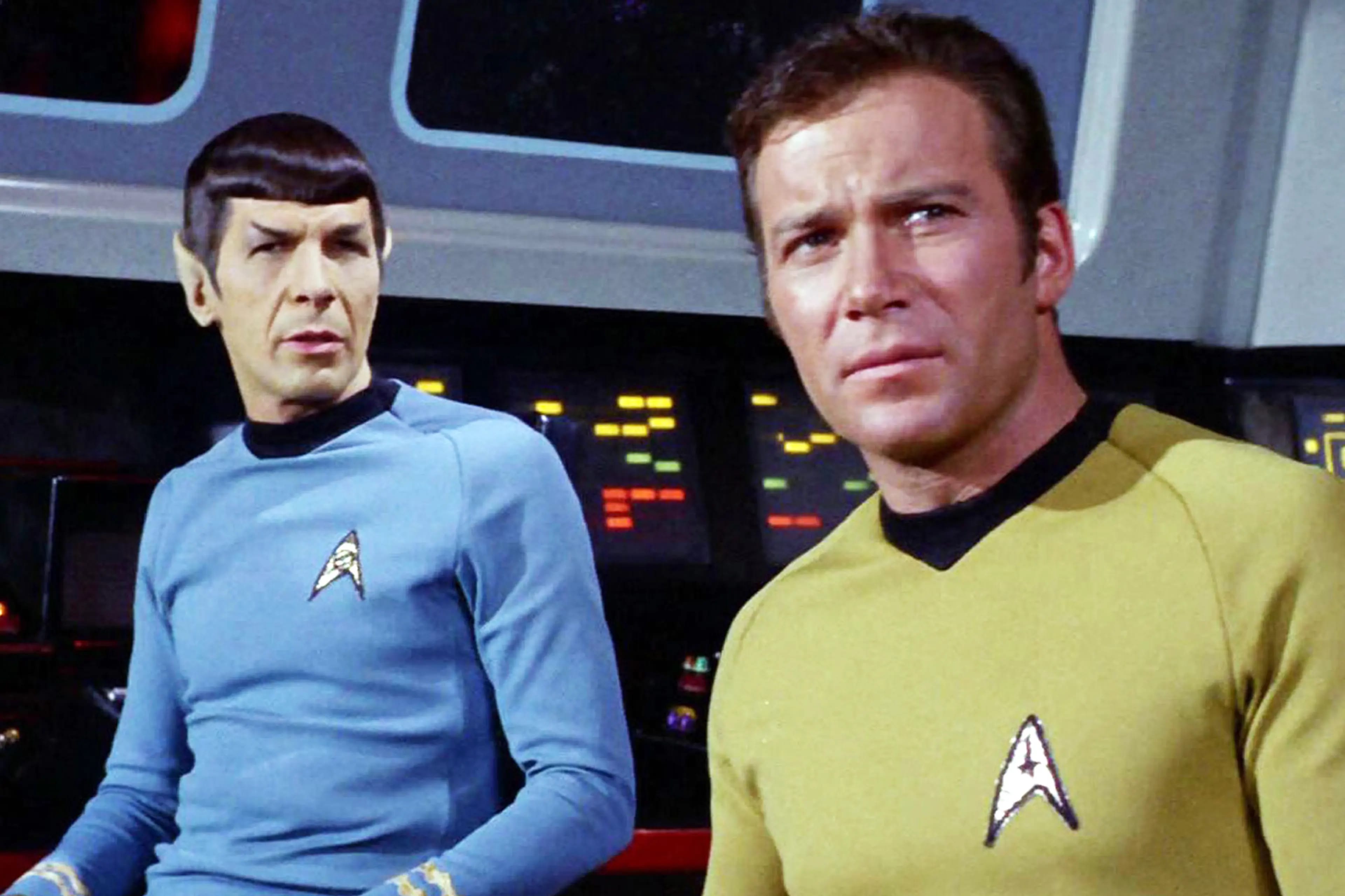 James T. Kirk standing with Spock aboard the original Enterprise.