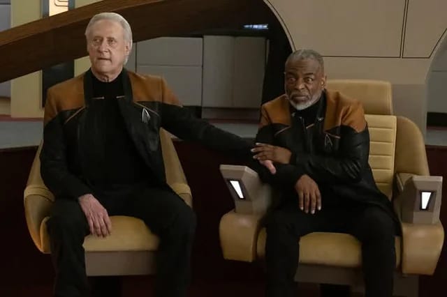 Older Geordi La Forge standing with the restored Data in the early 25th century.