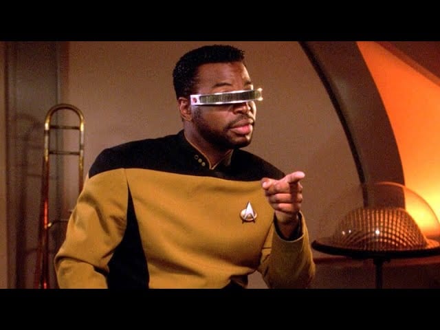 Geordi La Forge in a gold Starfleet uniform wearing his VISOR.