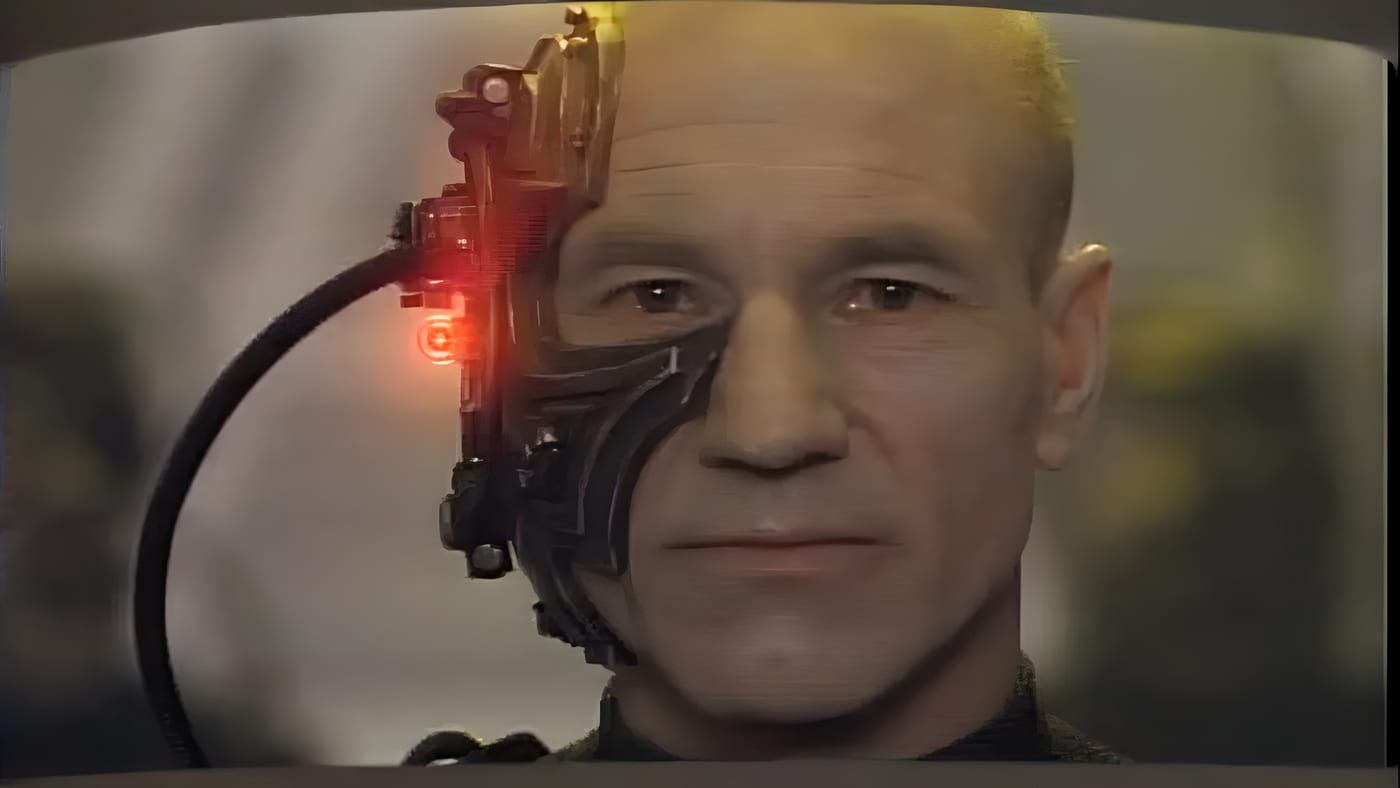Locutus of Borg head and shoulders, Borg implants and red sensor visible, tight portrait with curved screen edges.