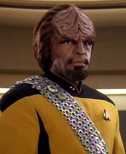 Worf in a Starfleet operations uniform with his Klingon sash.